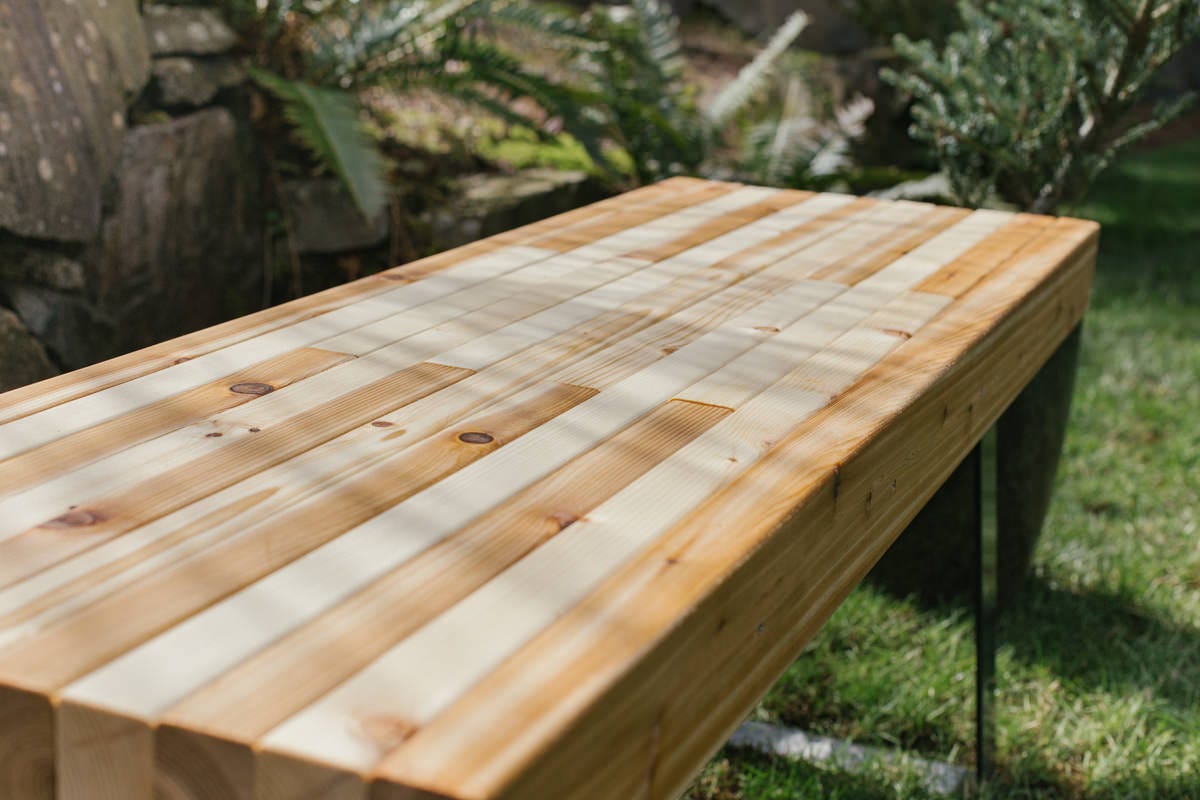 DIY mixed wood bench outside.