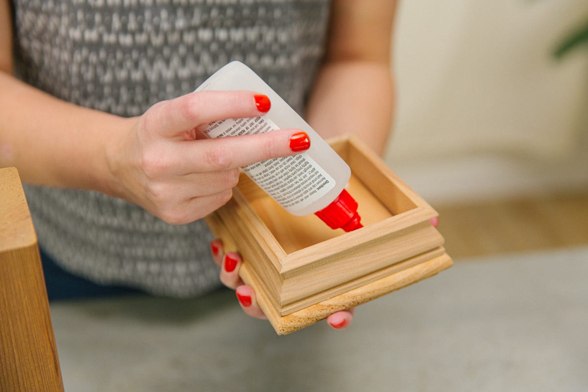 Applying wood glue to inside of fence post cap.