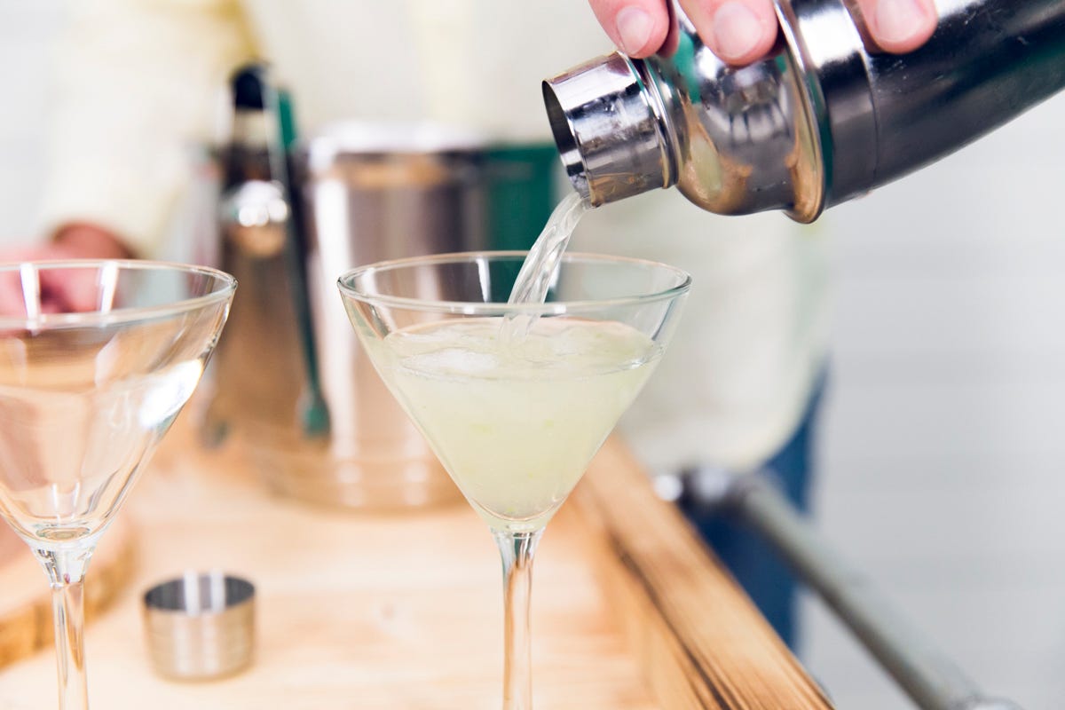 pouring drink into martini glass