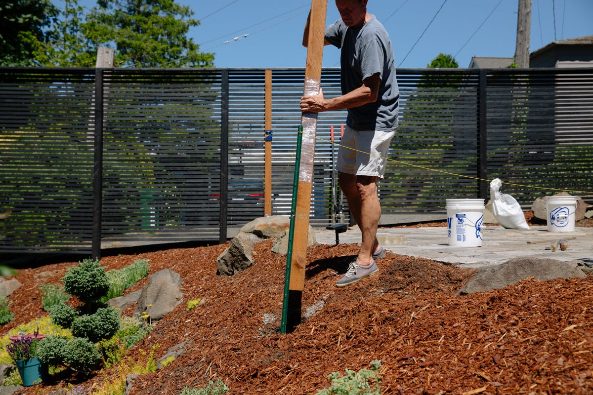 Inserting post with stringline attached into hole.