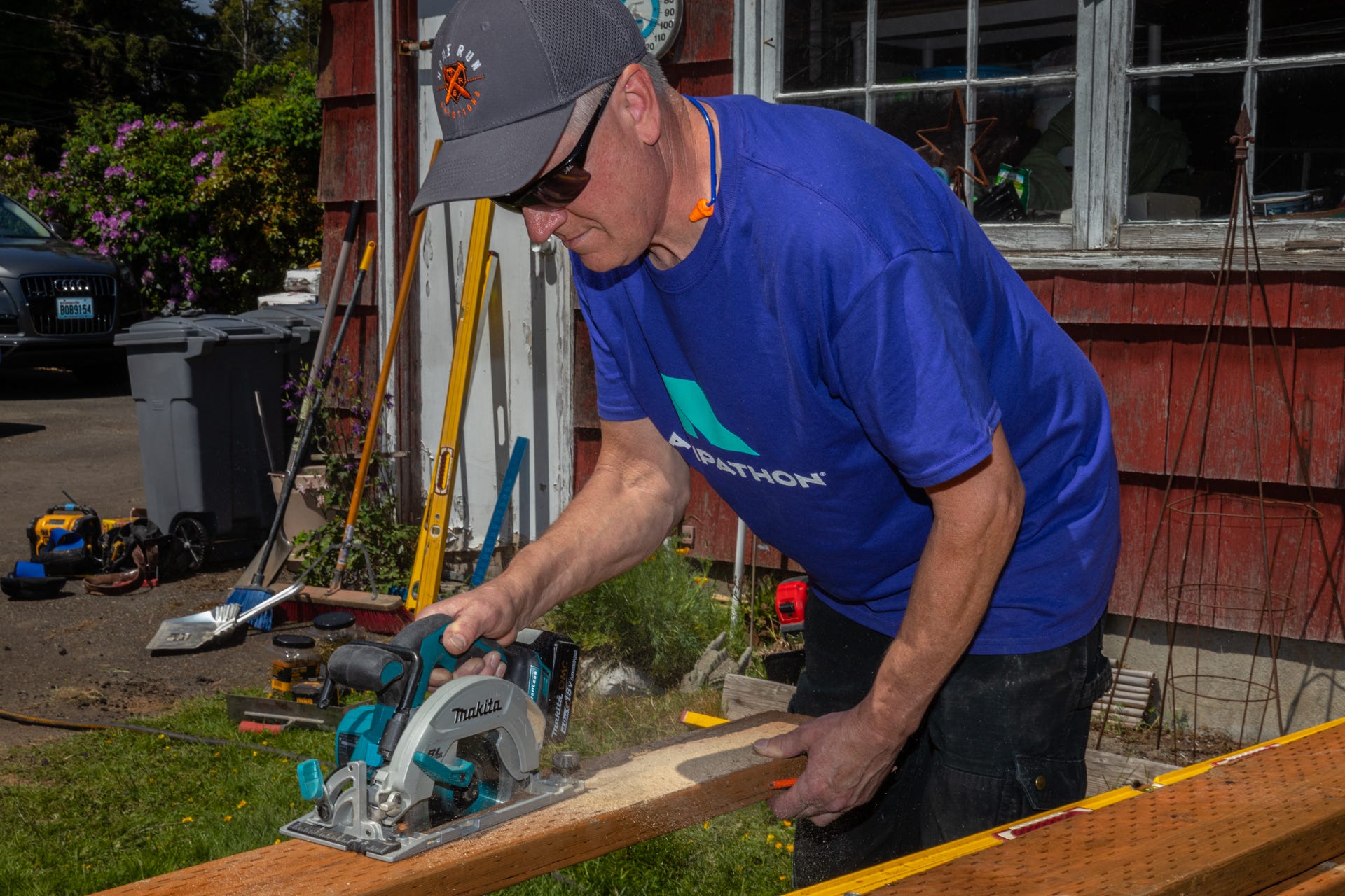 Person wearing a "Rampathon" T-shirt cutting lumber with a circular saw.