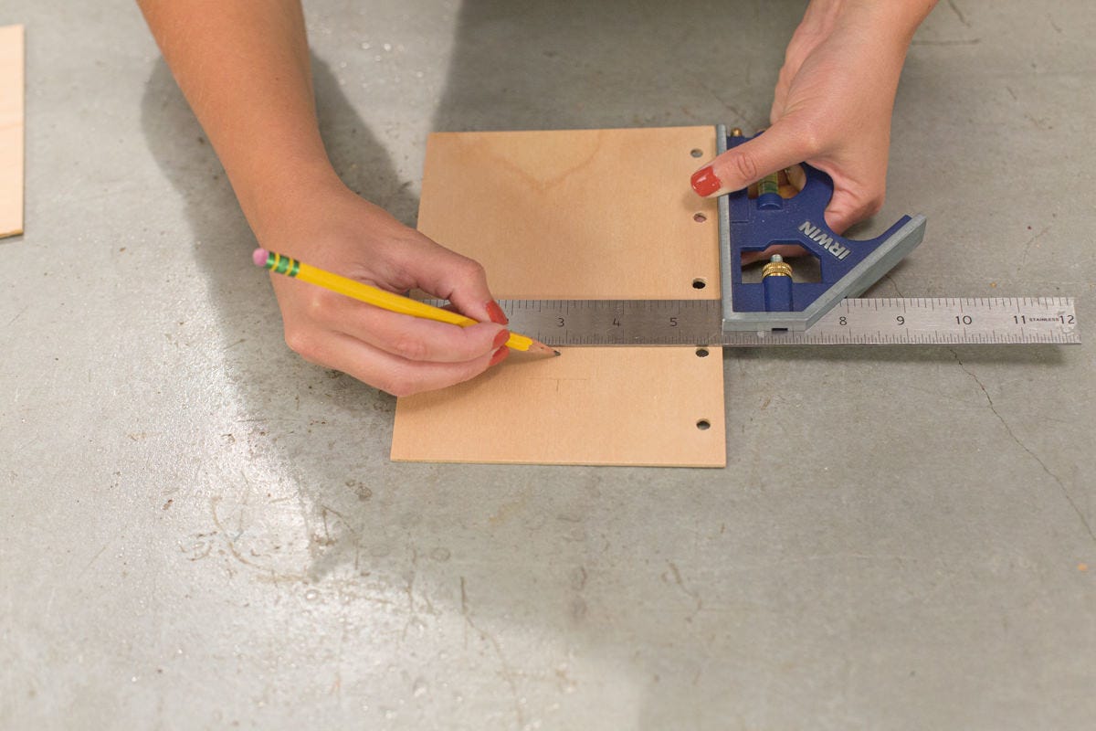 Drawing straight line on DIY school year journal cover with combination square.