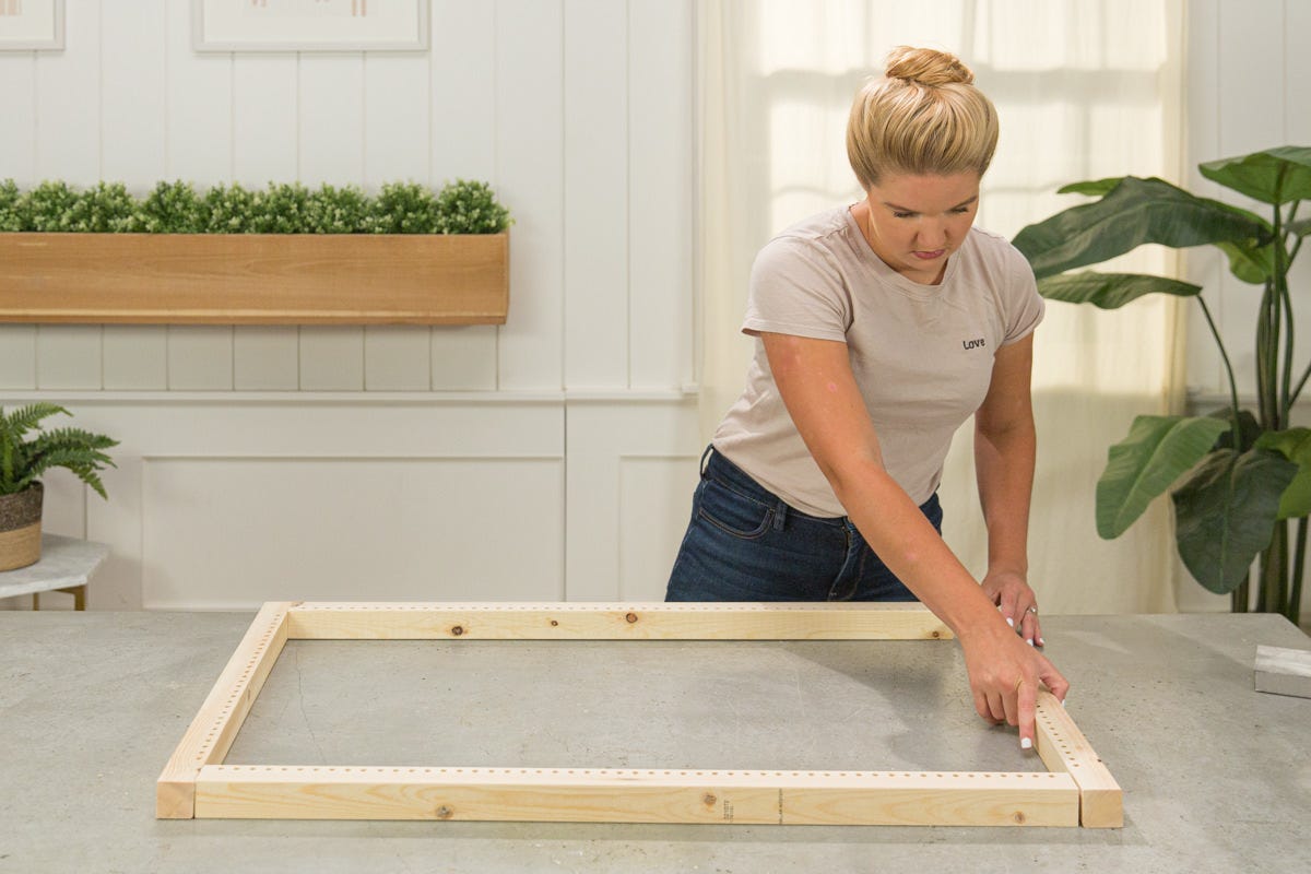 Arranging boards of DIY wooden rug loom in shape of frame.