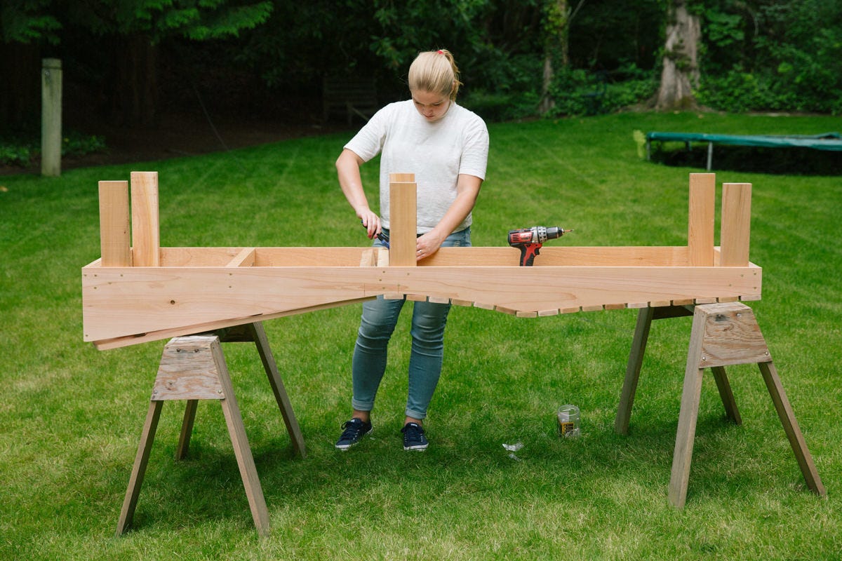 DIY wooden lounge chair assembly with six legs attached.