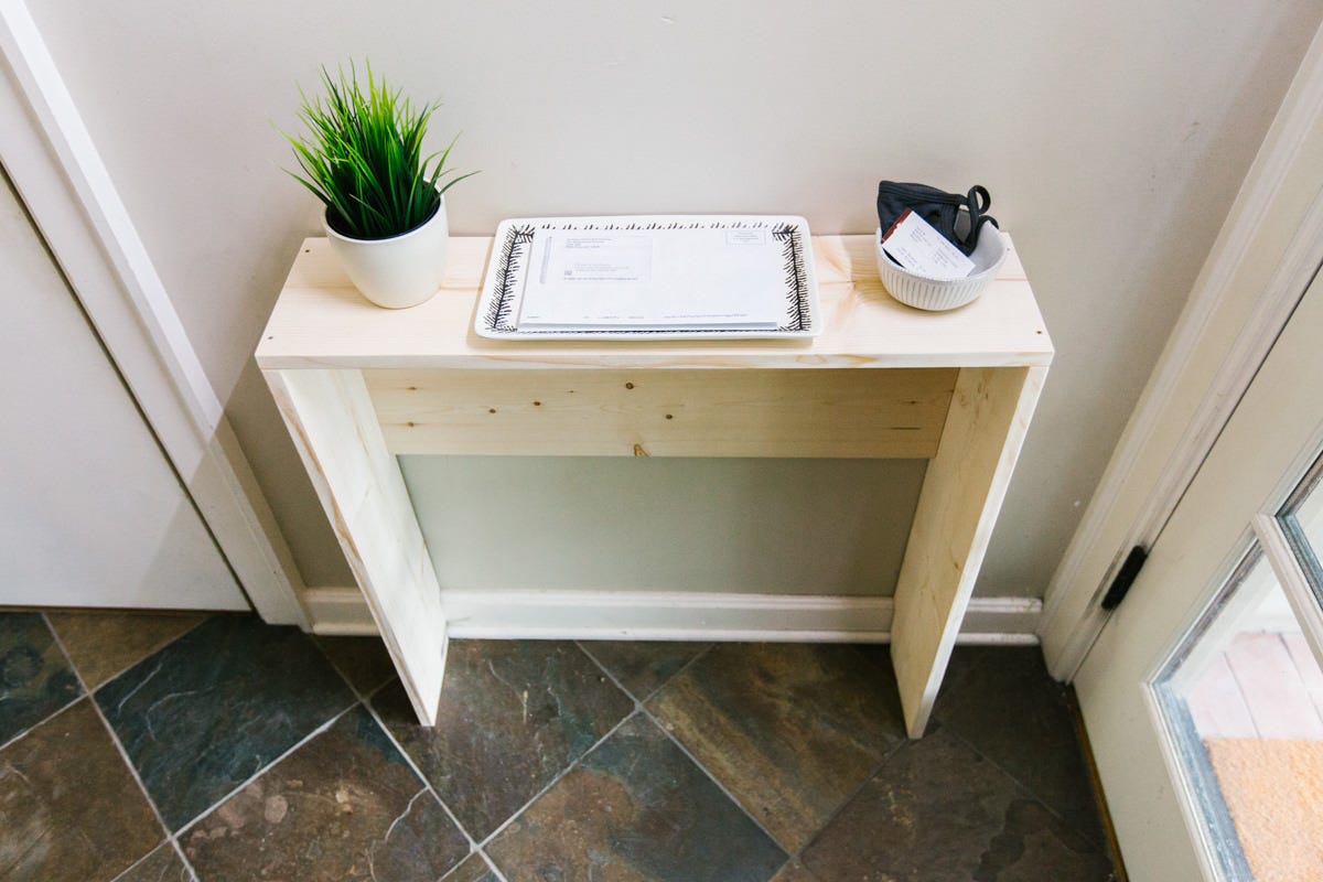 Wood DIY narrow entryway table with potted plant, mail tray, and small bowl.