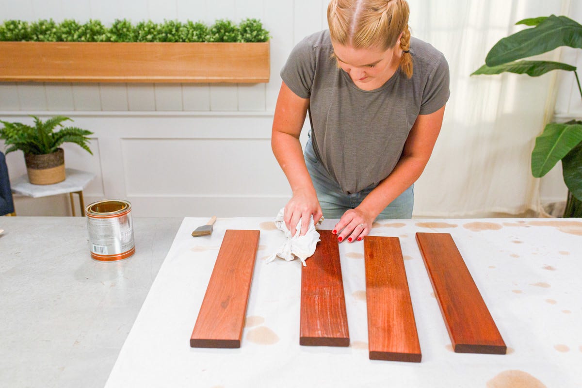 Wiping stained ipe boards with rag.