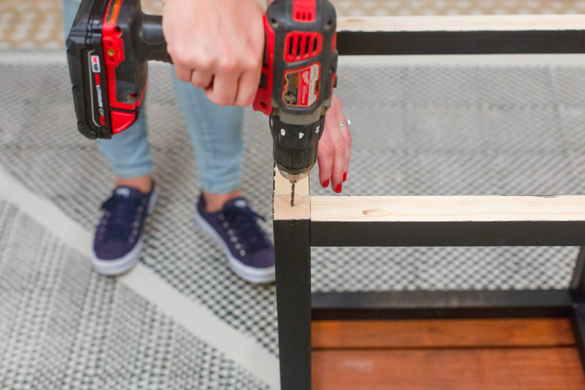 Pre-drilling hole in bottom corner of DIY wooden outdoor side table base.